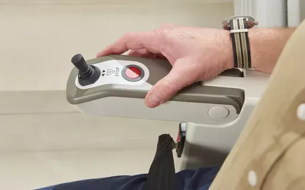 Access-HomeGlide-Joystick Image shows a mans hand on the armrest of the Access HomeGlide Outdoor stairlift