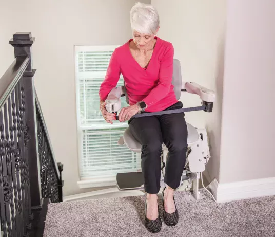 Elite-Curved Image shows a lady sitting on the Bruno Elite Curved stairlift