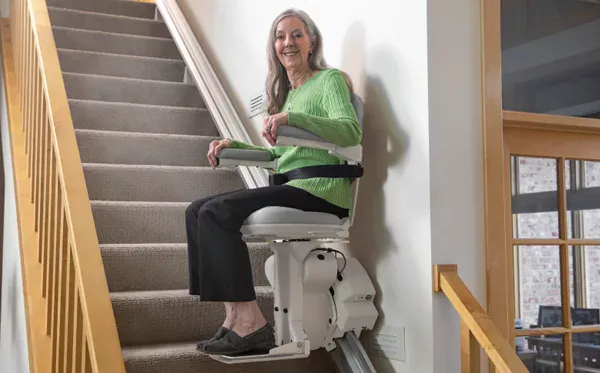 bruno-adjustable Image shows a lady using a stairlift. Image depicts the best stairlift company UK
