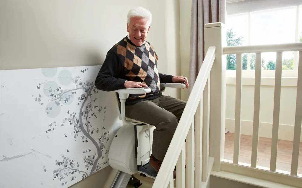 Image shows a man using a stairlift