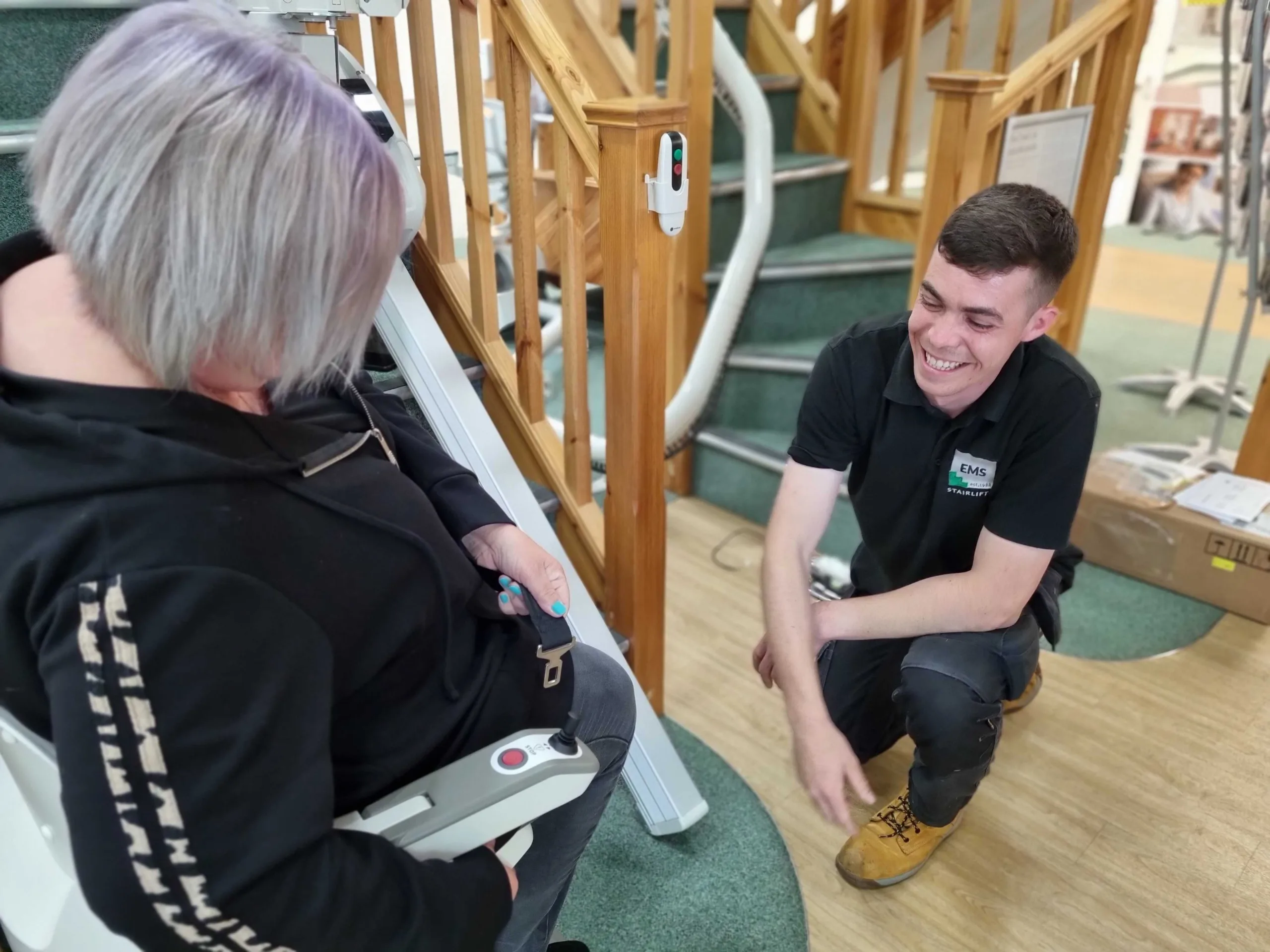 20230526_084719 Image shows an EMS engineer helping a lady to try out a stairlift